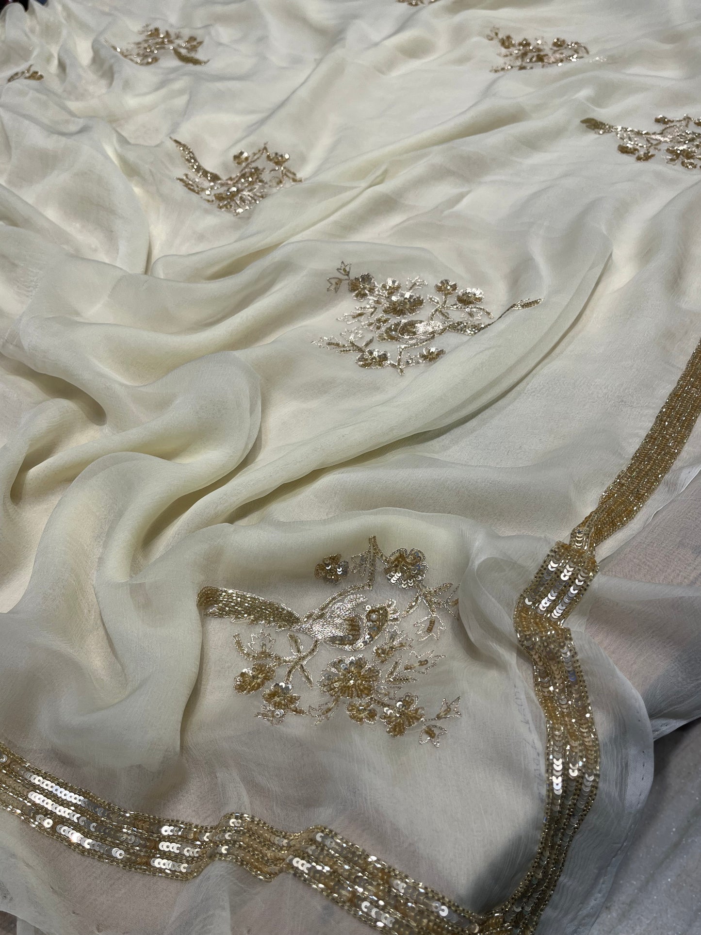 IVORY COLOUR CHIFFON HAND EMBROIDERED SAREE EMBELLISHED WITH CUTDANA, SEQUINS & AARI WORK
