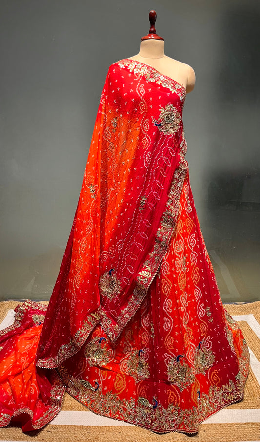 ORANGE & RED COLOUR PURE OJARIYA BANDHEJ LEHENGA WITH UNSTITCHED BLOUSE EMBELLISHED WITH GOTA PATTI, CUTDANA & ZARDOZI WORK