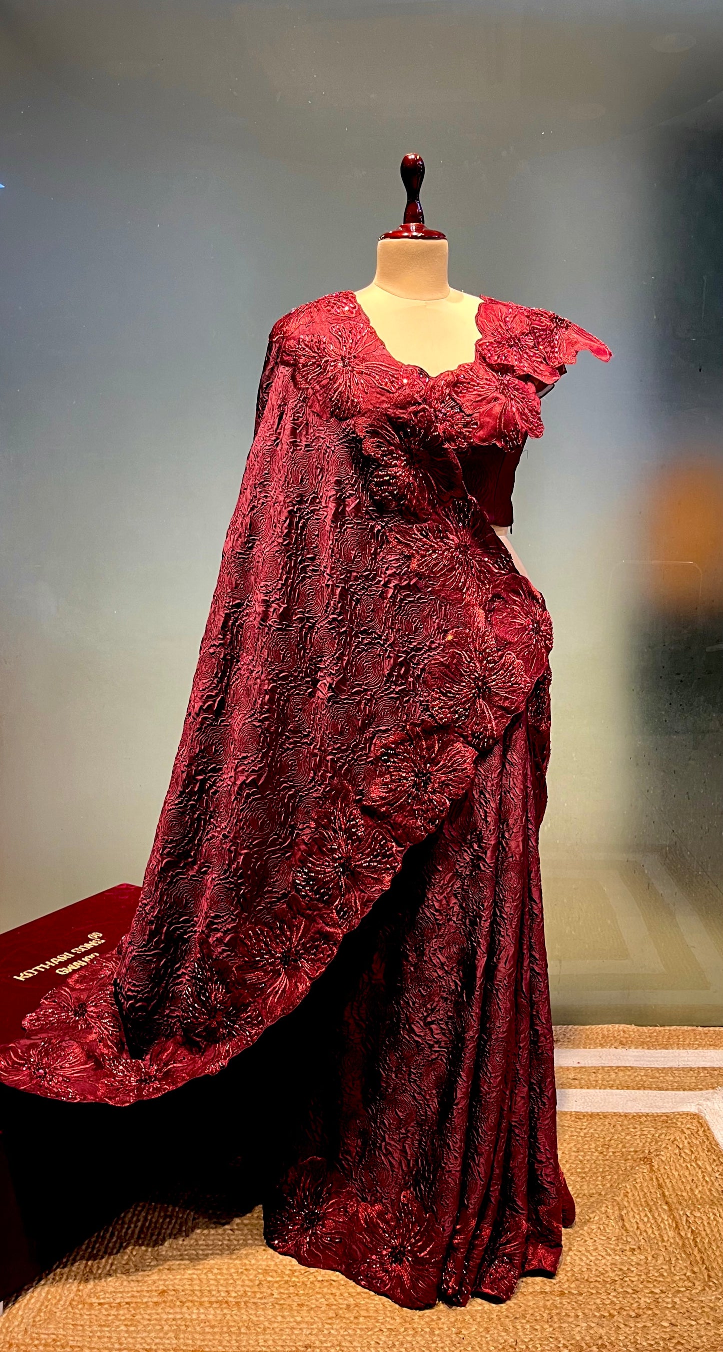MAROON COLOUR SATIN EMBOSSED PRINT SAREE WITH READYMADE BLOUSE EMBELLISHED WITH FLORAL APPLIQUE WORK BORDER