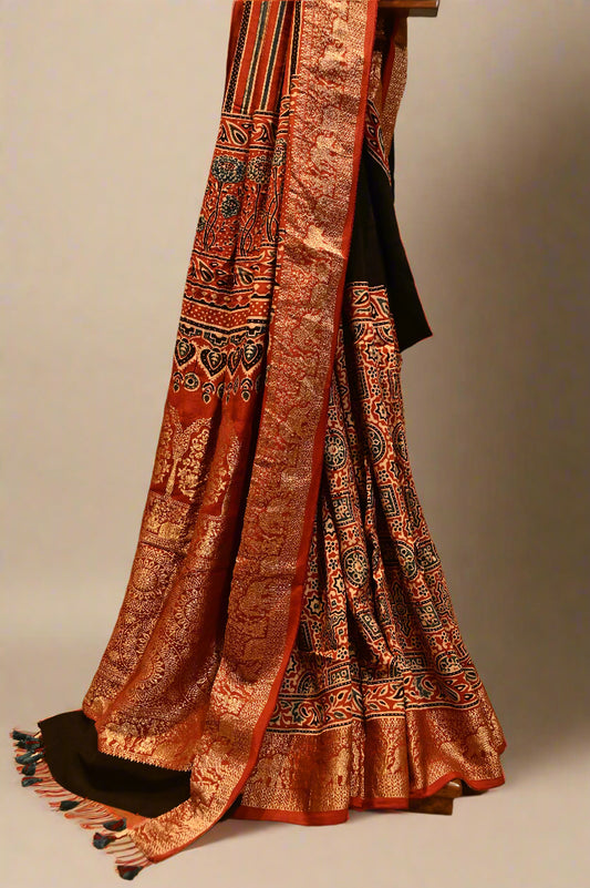 BLACK/RUST CONTRAST AJRAKH PRINT SAREE WITH RUST AJRAKH BLOUSE AND RICH BANARASI PALLA & BORDER IN PLANT-BASED SILK