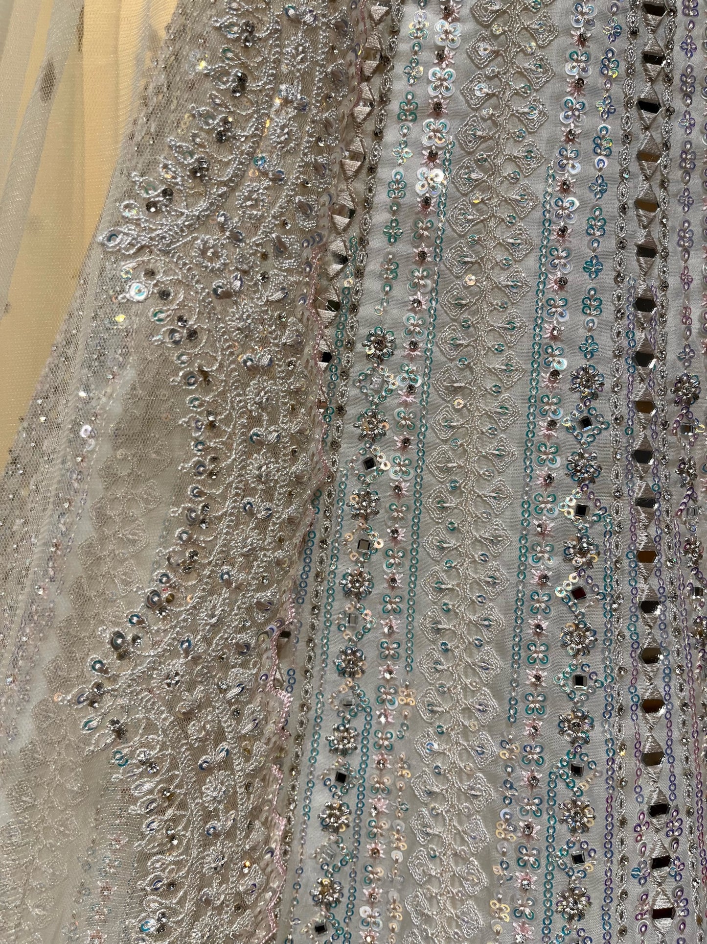 WHITE COLOUR NET EMBROIDERED LEHENGA WITH UNSTITCHED BLOUSE EMBELLISHED WITH RESHAM, MIRROR & SEQUINS WORK