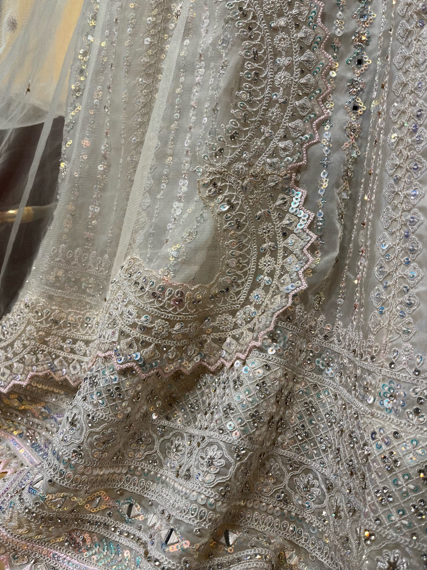 WHITE COLOUR NET EMBROIDERED LEHENGA WITH UNSTITCHED BLOUSE EMBELLISHED WITH RESHAM, MIRROR & SEQUINS WORK