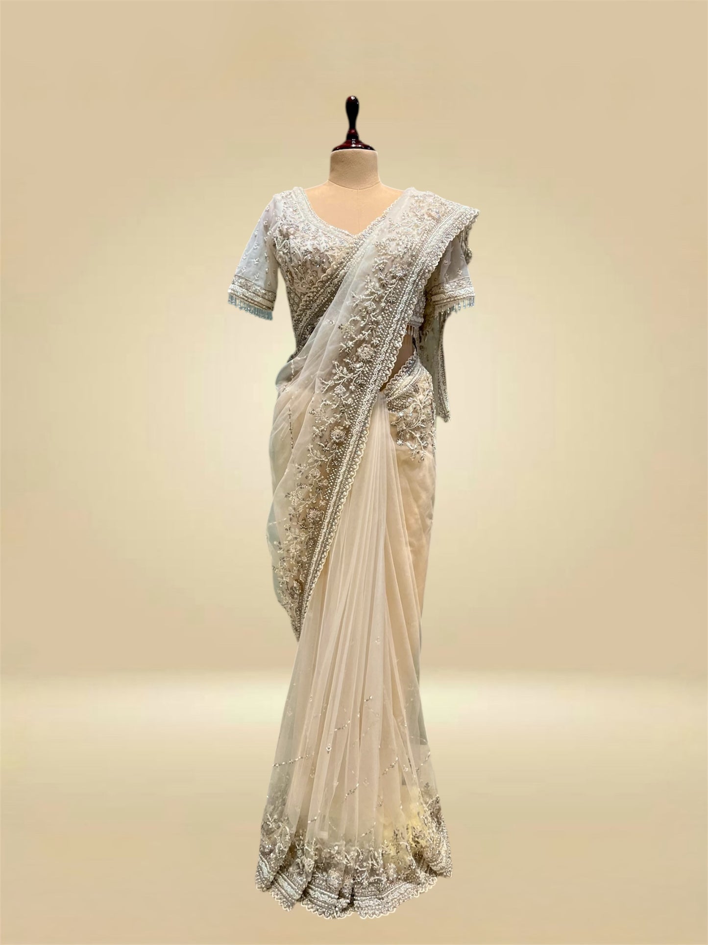 IVORY COLOUR NET SAREE EMBELLISHED WITH CUTDANA & SEQUINS, PAIRED WITH A READYMADE BLOUSE