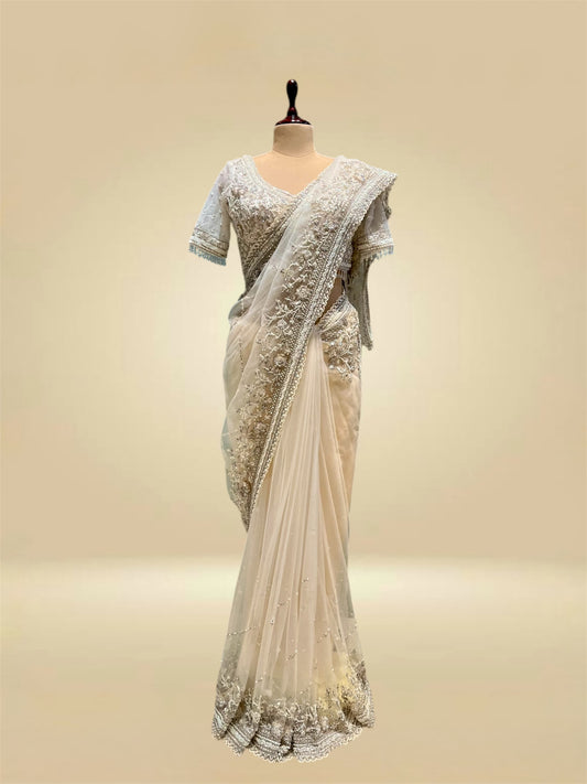IVORY COLOUR NET SAREE EMBELLISHED WITH CUTDANA & SEQUINS, PAIRED WITH A READYMADE BLOUSE