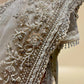 IVORY COLOUR NET SAREE EMBELLISHED WITH CUTDANA & SEQUINS, PAIRED WITH A READYMADE BLOUSE