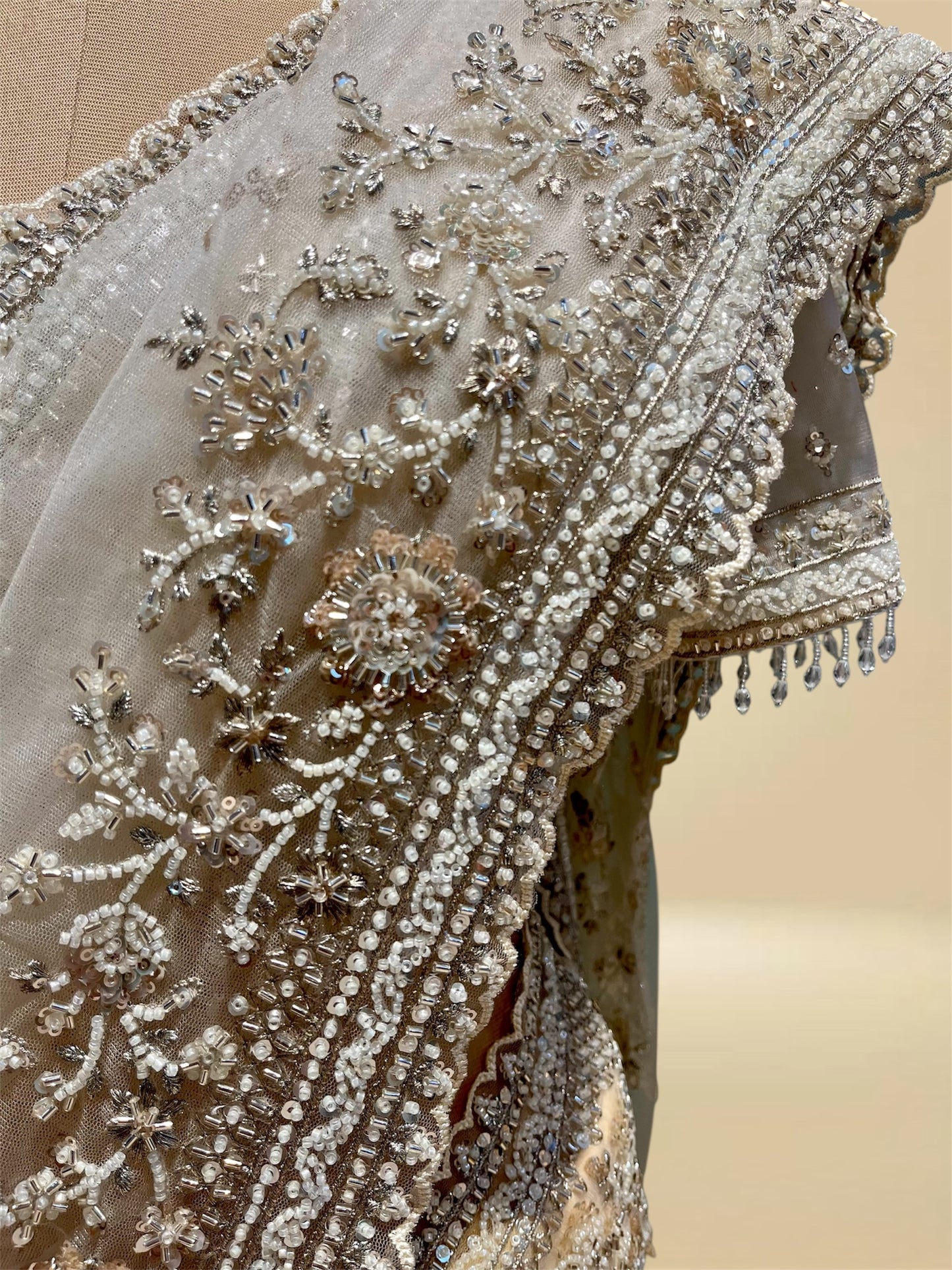 IVORY COLOUR NET SAREE EMBELLISHED WITH CUTDANA & SEQUINS, PAIRED WITH A READYMADE BLOUSE