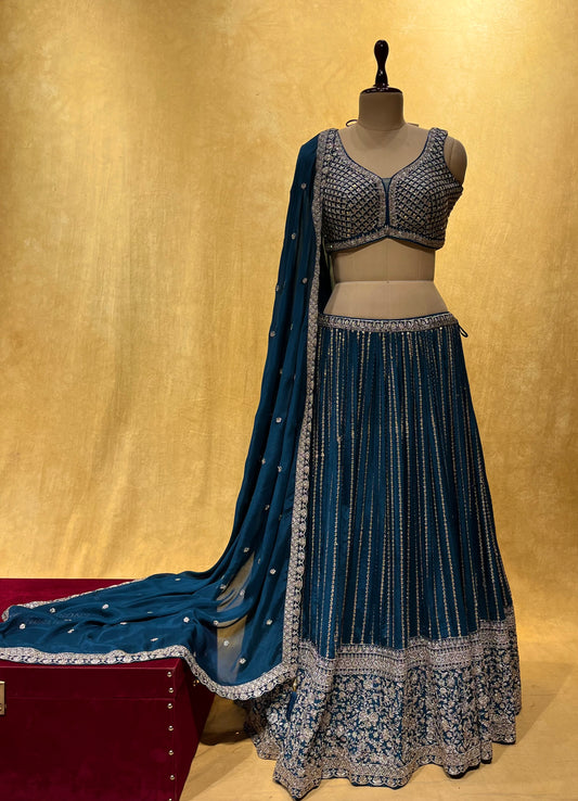 ( DELIVERY IN 25 DAYS ) TEAL BLUE COLOR CHINON LEHENGA WITH READYMADE CROP TOP BLOUSE EMBELLISHED WITH ZARI & CUTDANA WORK