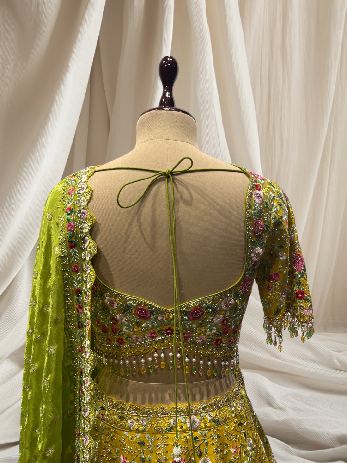 LEMON YELLOW LEHENGA WITH GREEN DUPATTA, SILK FABRIC, & RESHAM WORK EMBELLISHED WITH BEADS & TASSELS