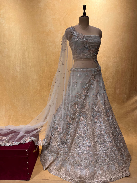 ( DELIVERY IN 25 DAYS ) GREY COLOR NET EMBROIDERED LEHENGA WITH UNSTITCHED BLOUSE EMBELLISHED WITH ZARI & SEQUINS WORK