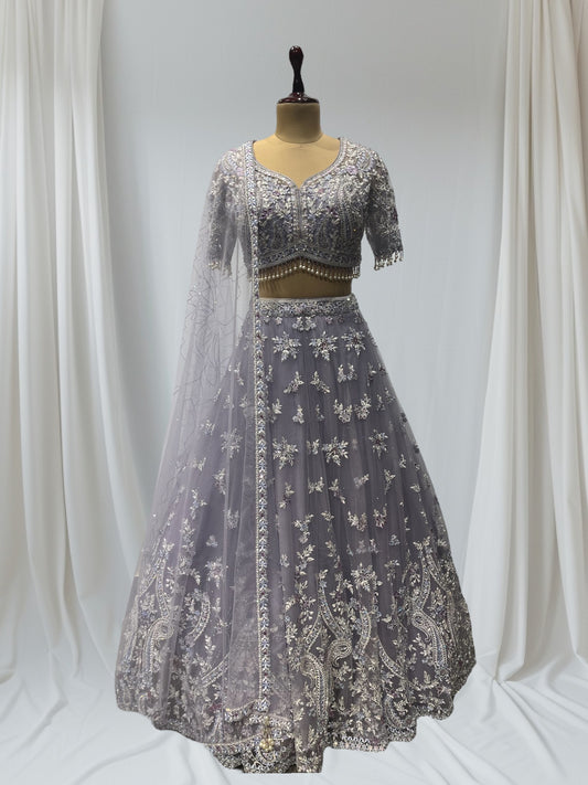 LAVENDER COLOR PAIRED WITH A CROP TOP CRAFTED DORI  AT THE BACK, FROM NET FABRIC IT FEATURES INTRICATE THREAD EMBROIDERY WITH MIRROR WORK AND PEARLS