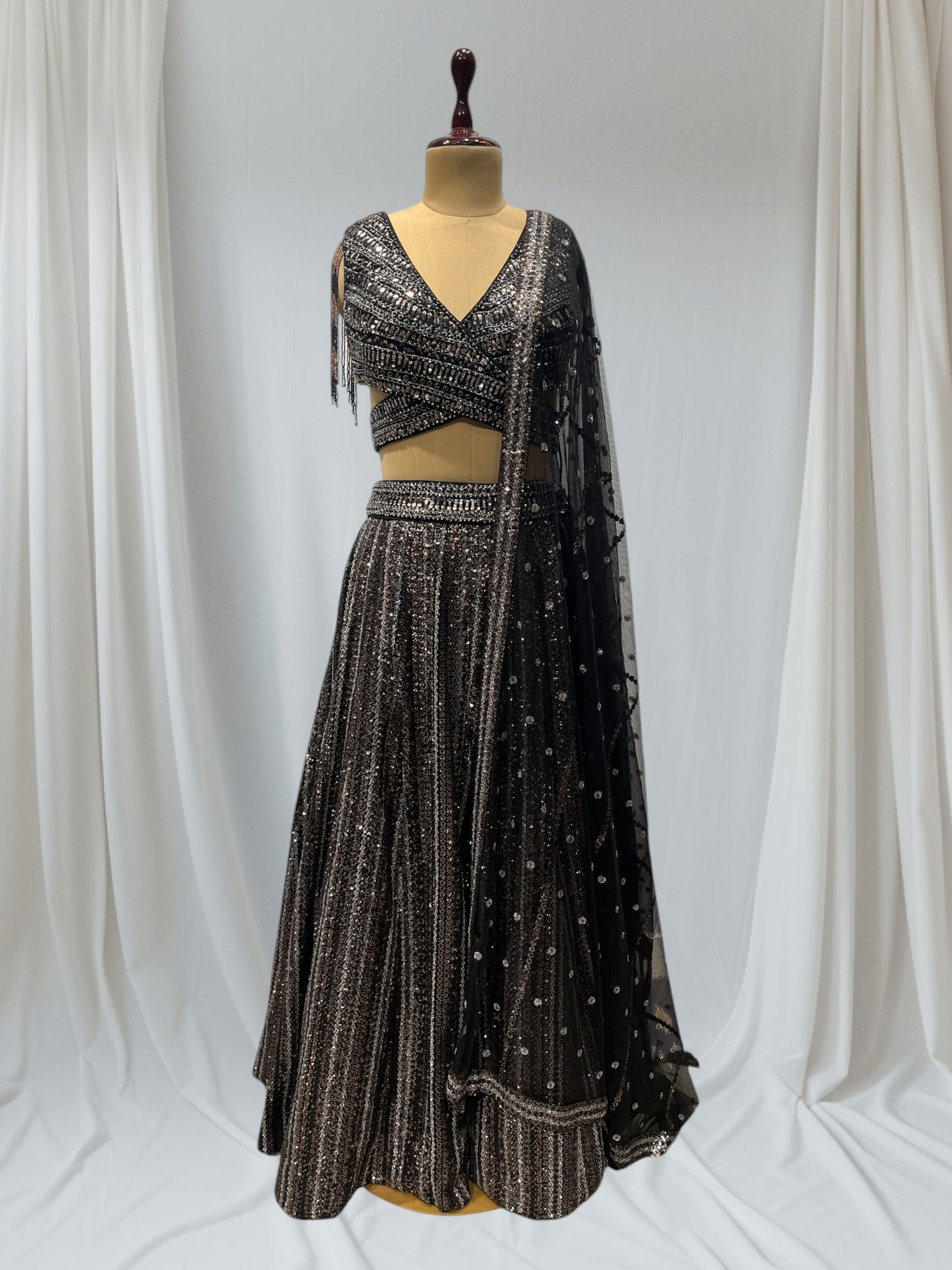 STUNNING BLACK SEQUIN LEHENGA FEATURING A V- NECK CROP TOP WITH EXQUISITE GOLDEN/SILVER SEQUINS WORK, IDEAL FOR A GLAMOROUS EVENING LOOK