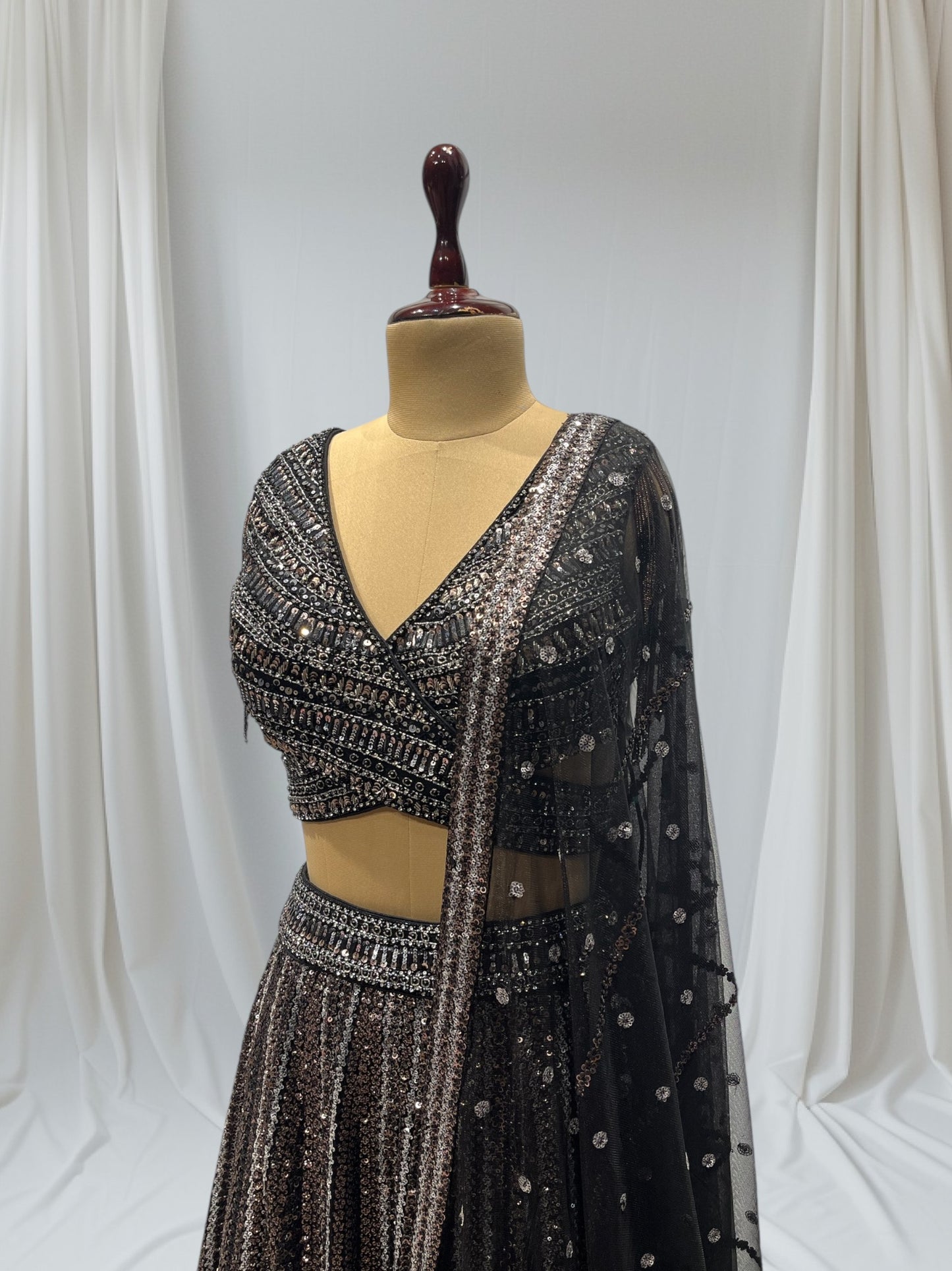 STUNNING BLACK SEQUIN LEHENGA FEATURING A V- NECK CROP TOP WITH EXQUISITE GOLDEN/SILVER SEQUINS WORK, IDEAL FOR A GLAMOROUS EVENING LOOK