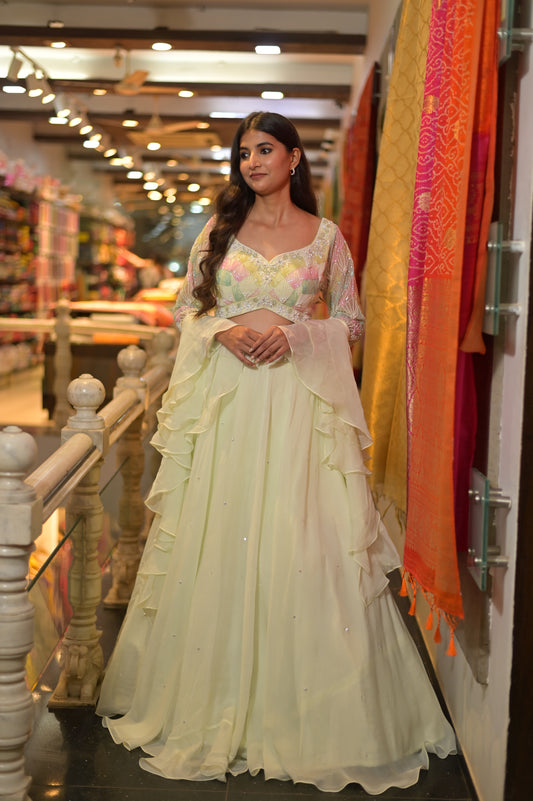 PISTA GREEN COLOUR GEORGETTE LEHENGA WITH HAND EMBROIDERED CROP TOP WITH RUFFLE DUPATTA EMBELLISHED WITH CUTDANA AND SEQUINS WORK