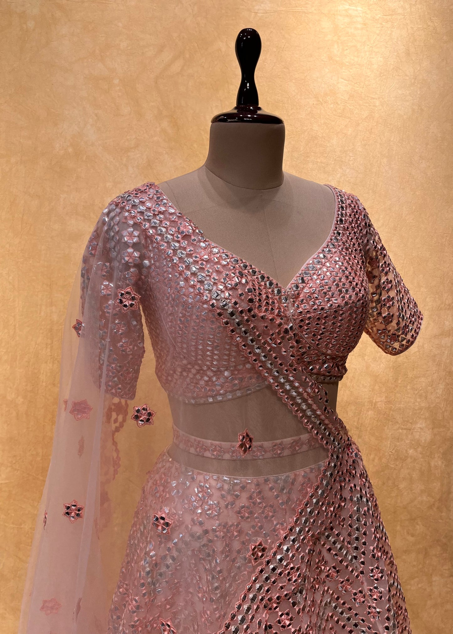 PEACH COLOUR NET EMBROIDERED LEHENGA WITH CROP TOP BLOUSE EMBELLISHED WITH MIRROR FOIL WORK