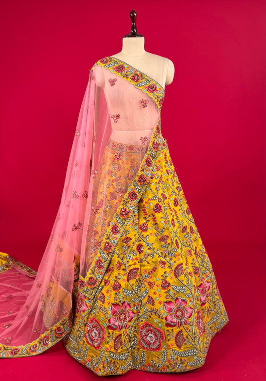 MUSTARD COLOUR SILK LEHENGA WITH UNSTITCHED BLOUSE & NET DUPATTA EMBELLISHED WITH RESHAM, SEQUINS & STONE WORK