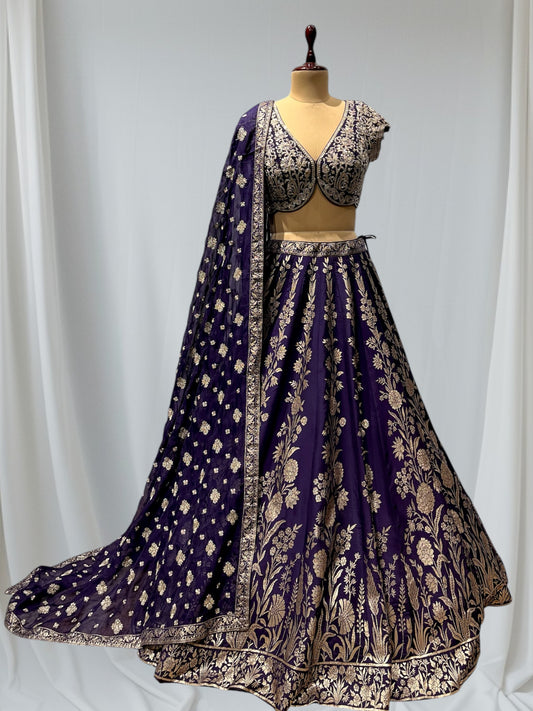 ( DELIVERY IN 20-25 DAYS ) PURPLE COLOR BANARASI LEHENGA WITH ORGANZA DUPPATTA EMBELLISHED WITH KASAB, CUTDANA AND SEQUINS WORK