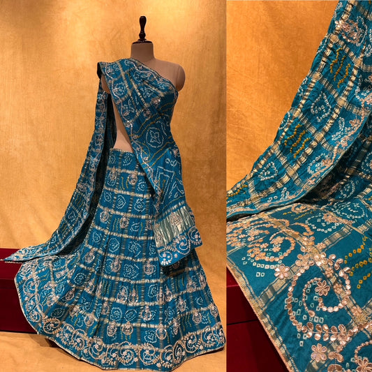 (DELIVERY IN 15-20 DAYS) TURQUOISE BLUE COLOUR BANDHANI-BANDHEJ GHARCHOLA LEHENGA EMBELLISHED WITH HAND WORK