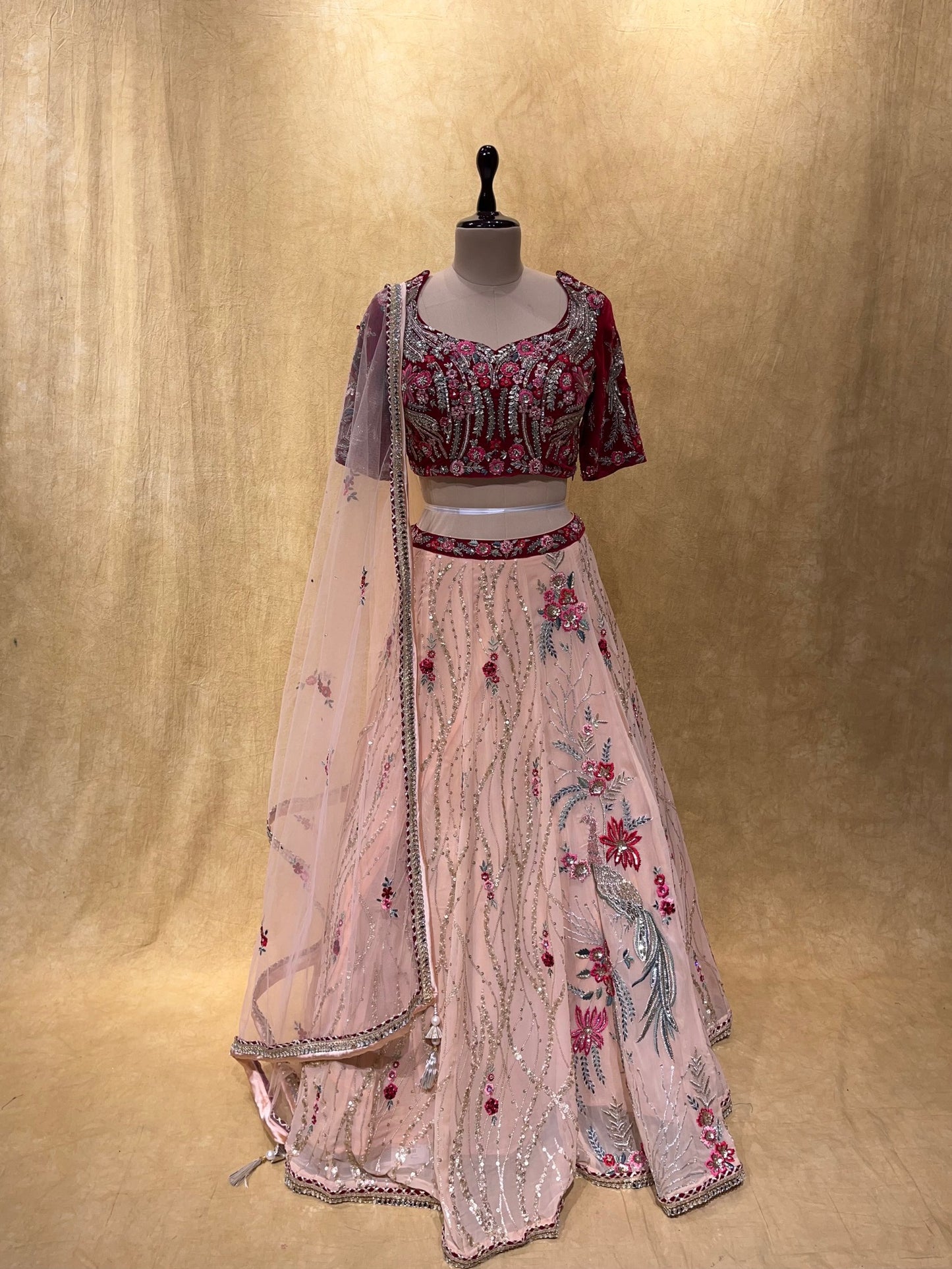 (DELIVERY IN 20 DAYS) BRIDESMAIDS READYMADE PEACH COLOUR GEORGETTE LEHENGA WITH MAROON VELVET CROP TOP BLOUSE EMBELLISHED WITH CUTDANA, SEQUINS & RESHAM WORK.