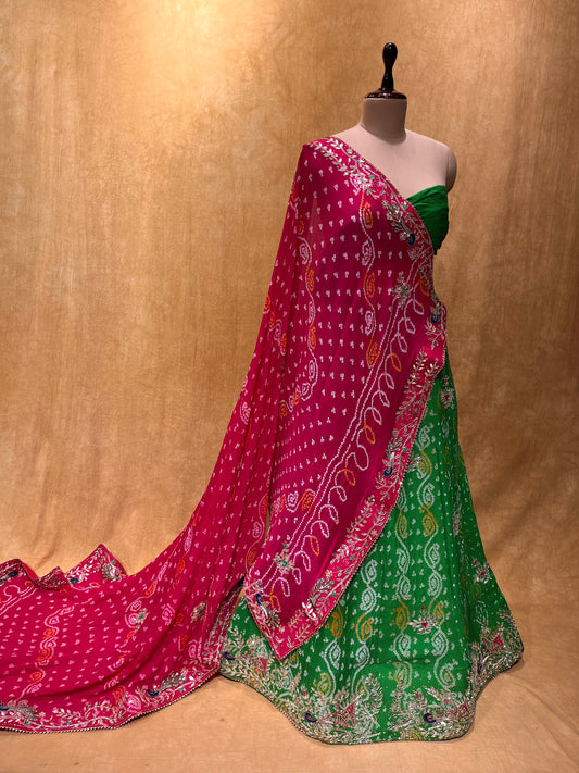 (DELIVERY IN 15-20 DAYS) GREEN COLOUR BANDHEJ LEHENGA WITH UNSTITCHED BLOUSE & CONTRAST DUPATTA EMBELLISHED WITH GOTA PATTI & CUTDANA WORK